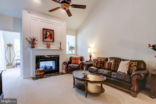 living area featuring carpet flooring, ceiling fan, a fireplace, and high vaulted ceiling