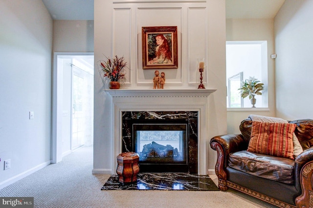 living area with a high end fireplace, plenty of natural light, carpet flooring, and baseboards
