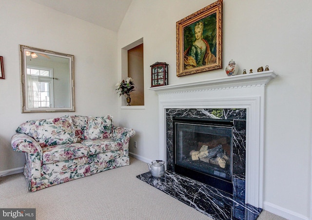 living room with carpet, lofted ceiling, baseboards, and a premium fireplace