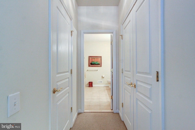 hallway with baseboards and light tile patterned flooring