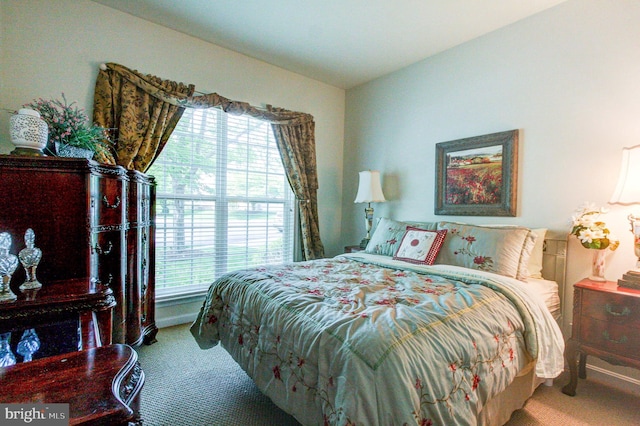 bedroom featuring carpet, multiple windows, and baseboards