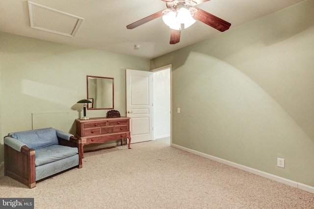 living area with carpet, baseboards, attic access, and a ceiling fan