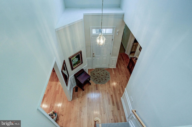 foyer with a towering ceiling, wood finished floors, and a chandelier