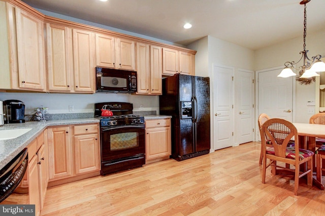 kitchen featuring black appliances, a chandelier, light brown cabinetry, light wood finished floors, and recessed lighting