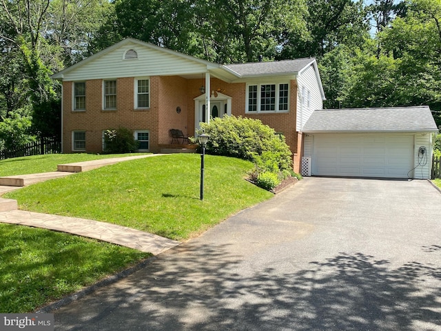6205 Oak Hill Dr, Sykesville, MD 21784 - split foyer home featuring brick siding, a front yard, driveway, a garage, and view of scattered trees
