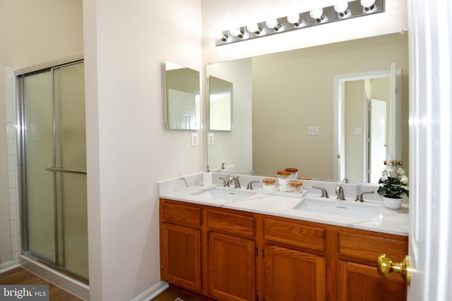 43193 Ribboncrest Ter, Ashburn, VA 20147 - full bath with double vanity, a shower with shower door, and wood finished floors