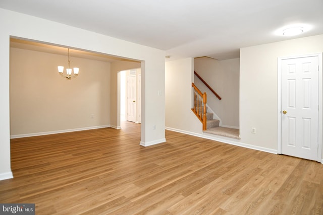 43193 Ribboncrest Ter, Ashburn, VA 20147 - unfurnished living room with light wood-type flooring, a chandelier, and stairs
