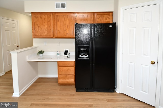 43193 Ribboncrest Ter, Ashburn, VA 20147 - kitchen featuring black fridge with ice dispenser, brown cabinets, light countertops, and light wood-type flooring