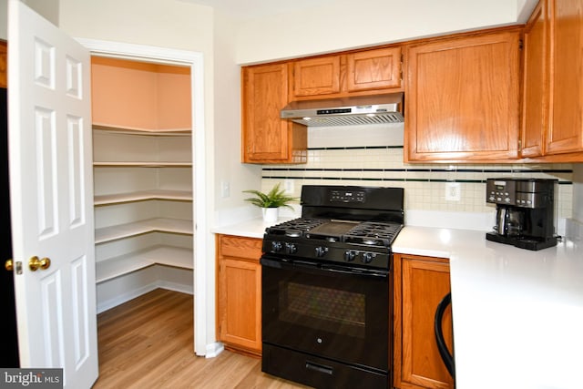 43193 Ribboncrest Ter, Ashburn, VA 20147 - kitchen with gas stove, ventilation hood, light countertops, light wood-style flooring, and decorative backsplash