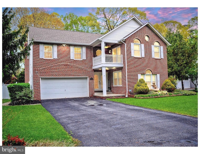410 Metropolitan Blvd, Pasadena, MD 21122 - view of front of property with a balcony, asphalt driveway, a garage, and brick siding