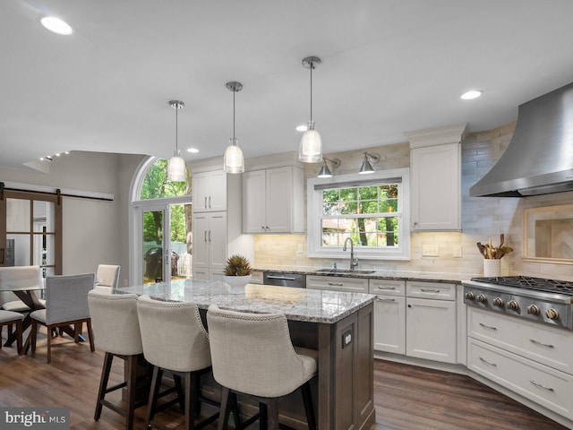 410 Metropolitan Blvd, Pasadena, MD 21122 - kitchen with a sink, wall chimney range hood, stainless steel appliances, backsplash, and a kitchen island