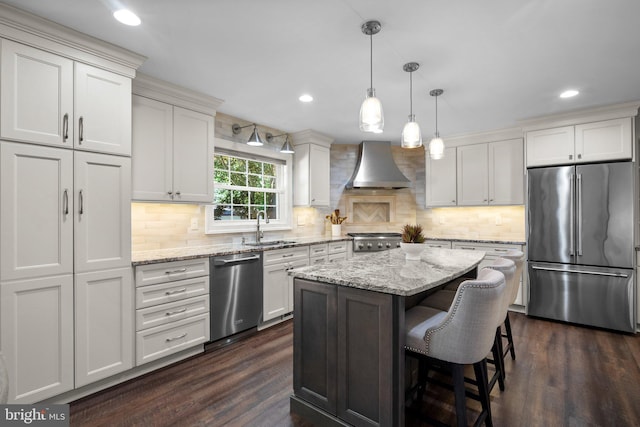 410 Metropolitan Blvd, Pasadena, MD 21122 - kitchen featuring appliances with stainless steel finishes, wall chimney exhaust hood, dark wood-style floors, a sink, and a center island