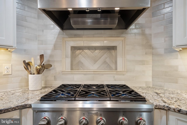 410 Metropolitan Blvd, Pasadena, MD 21122 - kitchen view of wall chimney exhaust hood, decorative backsplash, stove, white cabinetry, and light stone counters