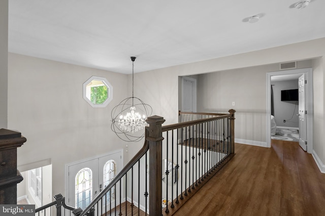 410 Metropolitan Blvd, Pasadena, MD 21122 - corridor featuring wood finished floors, a chandelier, an upstairs landing, and baseboards