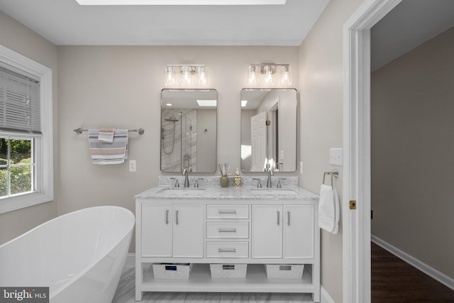 410 Metropolitan Blvd, Pasadena, MD 21122 - full bathroom featuring a stall shower, baseboards, double vanity, and a freestanding tub