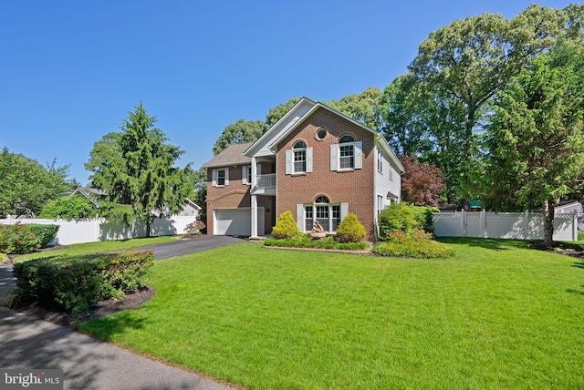 410 Metropolitan Blvd, Pasadena, MD 21122 - colonial-style house with a garage, asphalt driveway, brick siding, and a balcony