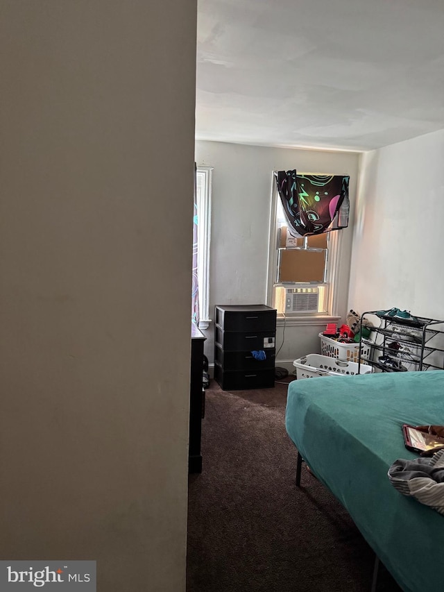 bedroom featuring dark carpet and cooling unit