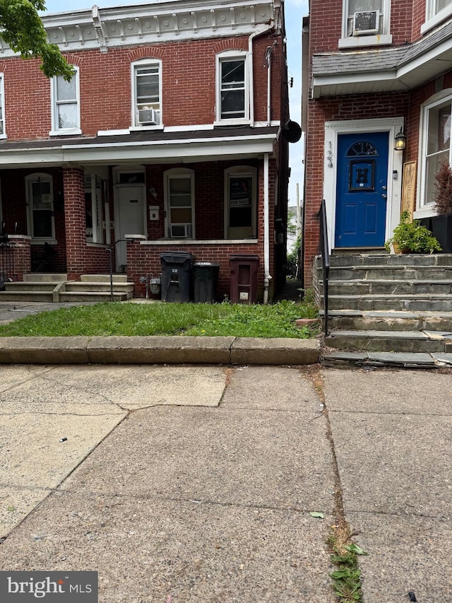 doorway to property featuring brick siding and covered porch