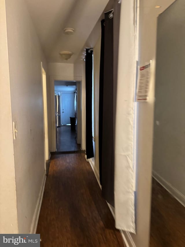 corridor featuring wood finished floors and baseboards