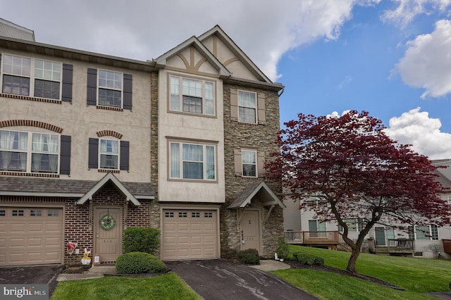 multi unit property with asphalt driveway, stone siding, stucco siding, and a garage