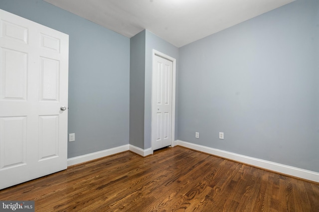 3322 Ely Pl SE, Washington, DC 20019 - unfurnished bedroom featuring baseboards, dark wood-type flooring, and a closet