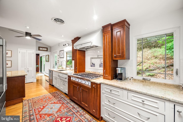 kitchen featuring custom exhaust hood, a ceiling fan, vaulted ceiling, backsplash, and a sink