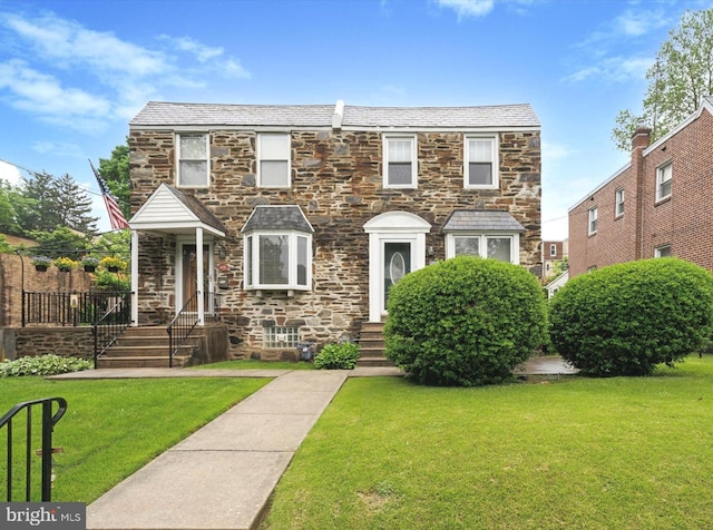 view of front of property featuring stone siding and a front lawn