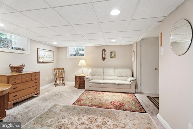 carpeted living area featuring a paneled ceiling, recessed lighting, and baseboards