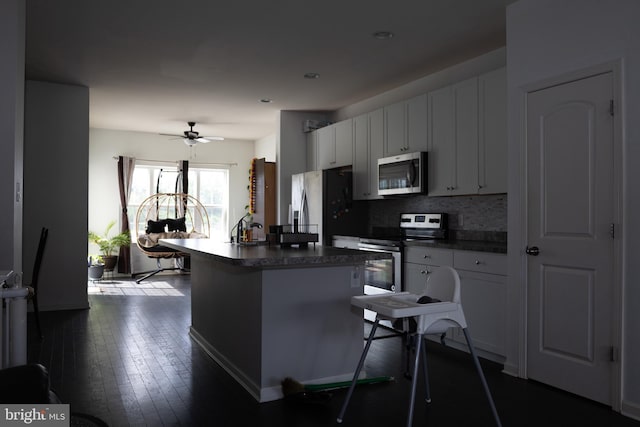 847 Lissicasey Loop, Middletown, DE 19709 - kitchen with stainless steel appliances, dark countertops, a ceiling fan, and a center island