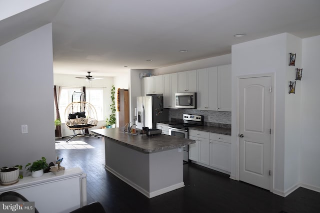 847 Lissicasey Loop, Middletown, DE 19709 - kitchen featuring appliances with stainless steel finishes, dark countertops, backsplash, dark wood finished floors, and white cabinets