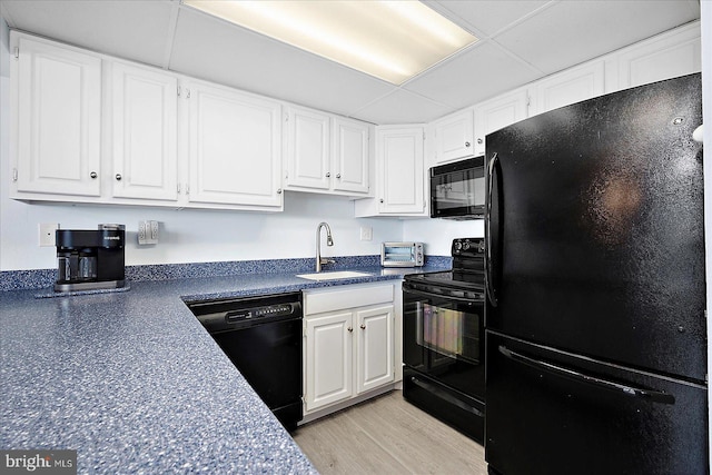 6007 Atlantic Ave Unit 207, Ocean City, MD 21842 - kitchen with black appliances, a sink, dark countertops, and white cabinetry