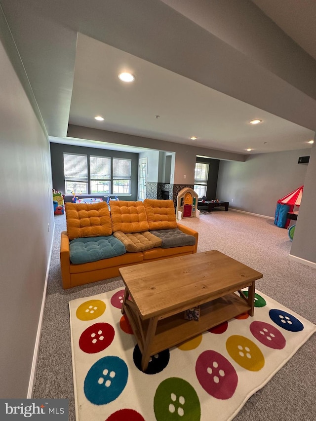carpeted living area featuring baseboards and recessed lighting