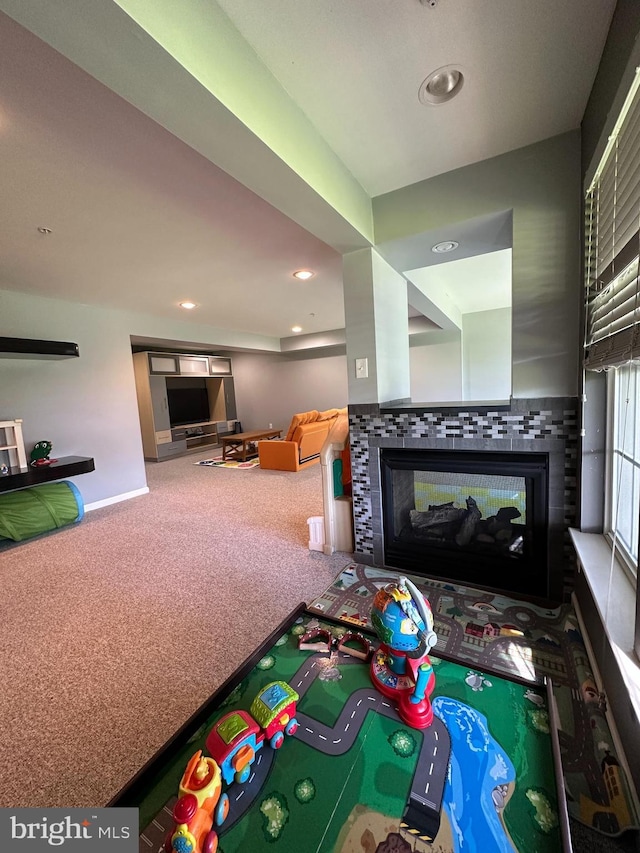 recreation room with a multi sided fireplace, carpet, baseboards, and recessed lighting