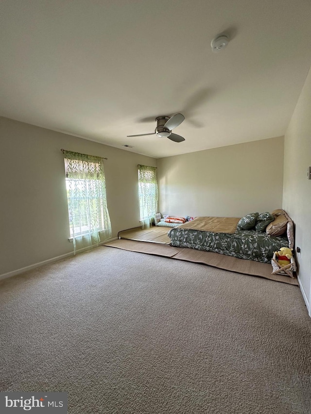 unfurnished bedroom with carpet flooring, baseboards, and a ceiling fan