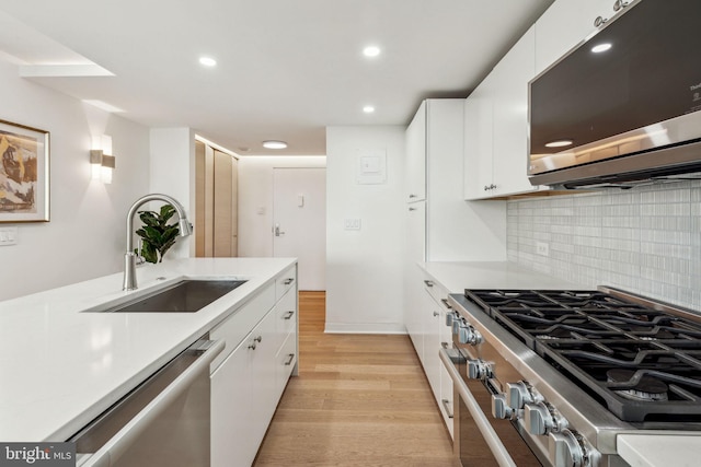604 S Washington Sq Unit 2917, Philadelphia, PA 19106 - kitchen featuring stainless steel appliances, a sink, light countertops, light wood-type flooring, and white cabinets