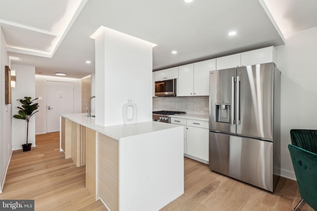 604 S Washington Sq Unit 2917, Philadelphia, PA 19106 - kitchen featuring appliances with stainless steel finishes, light wood-type flooring, white cabinets, light countertops, and recessed lighting