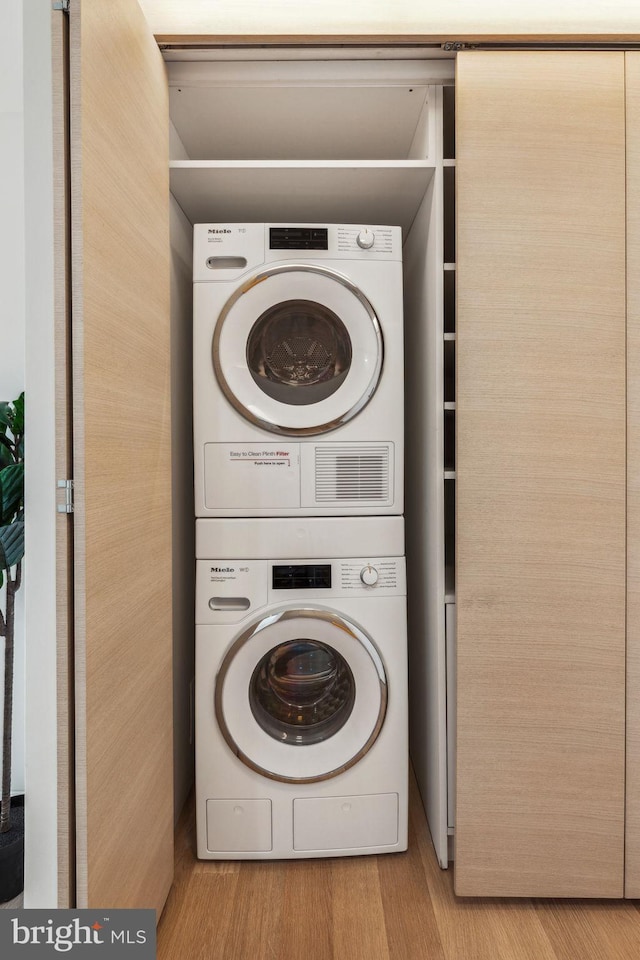 604 S Washington Sq Unit 2917, Philadelphia, PA 19106 - laundry room featuring stacked washing machine and dryer and wood finished floors