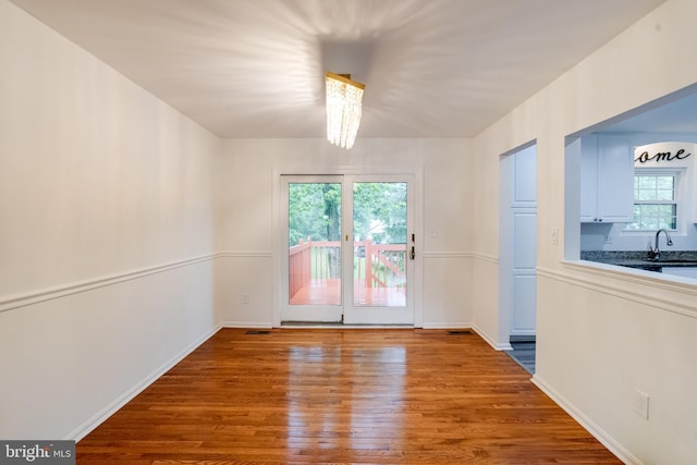 5 Wood Oak, Nottingham, MD 21236 - unfurnished room with wood finished floors and a chandelier