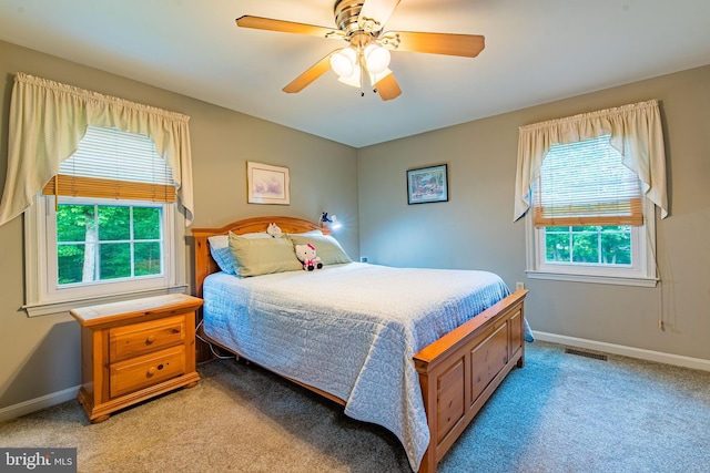 bedroom featuring light carpet, baseboards, and a ceiling fan