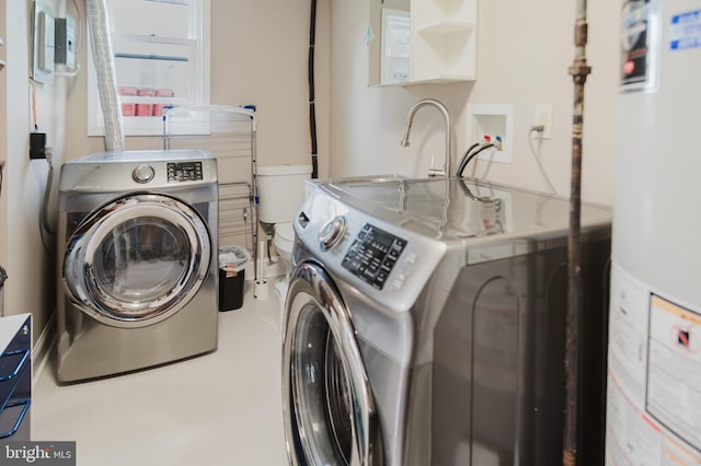 laundry room featuring washing machine and clothes dryer and water heater