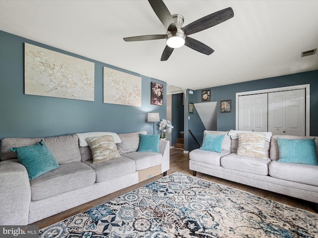 living area featuring wood finished floors, ceiling fan, and baseboards