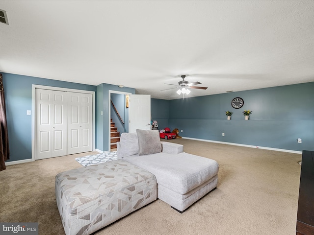 carpeted bedroom with a closet, baseboards, and ceiling fan