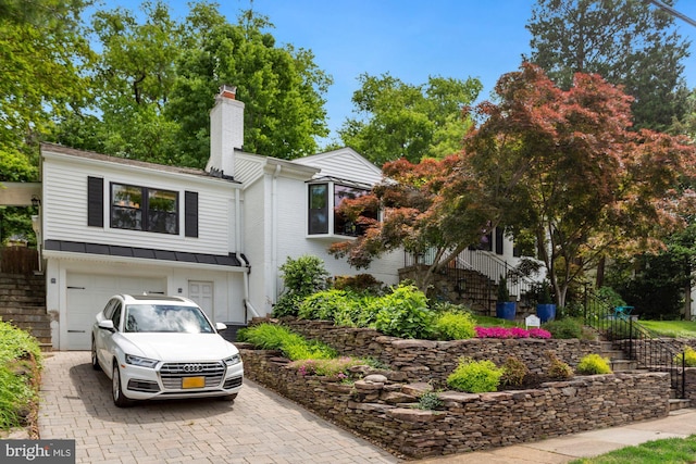 2901 N Rochester St, Arlington, VA 22213 - view of front facade with a chimney, decorative driveway, an attached garage, board and batten siding, and stairway