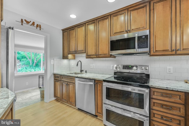 2901 N Rochester St, Arlington, VA 22213 - kitchen featuring appliances with stainless steel finishes, a sink, brown cabinetry, and baseboards