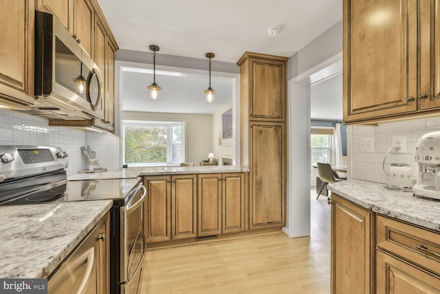 2901 N Rochester St, Arlington, VA 22213 - kitchen with stainless steel appliances, brown cabinets, light wood-style flooring, and backsplash