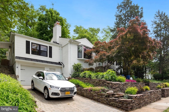 2901 N Rochester St, Arlington, VA 22213 - view of front of house featuring decorative driveway, a chimney, a garage, a standing seam roof, and stairs