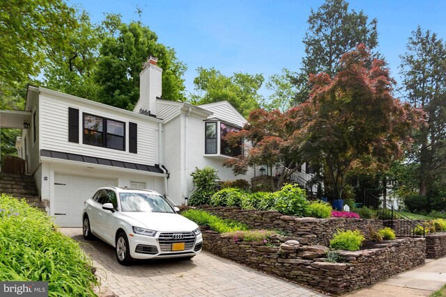 2901 N Rochester St, Arlington, VA 22213 - view of front facade featuring decorative driveway, a chimney, a garage, a standing seam roof, and metal roof