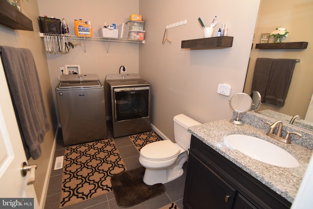 359 Eagle Way, Smyrna, DE 19977 - bathroom with washing machine and clothes dryer, toilet, vanity, tile patterned floors, and baseboards