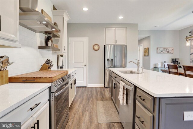 3118 Grove Ct, Mechanicsburg, PA 17055 - kitchen with appliances with stainless steel finishes, a sink, wood finished floors, wall chimney exhaust hood, and white cabinets