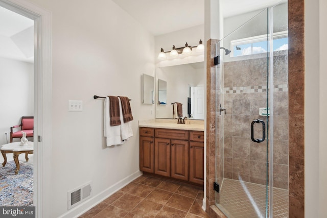 full bath with a stall shower, vanity, baseboards, and tile patterned floors